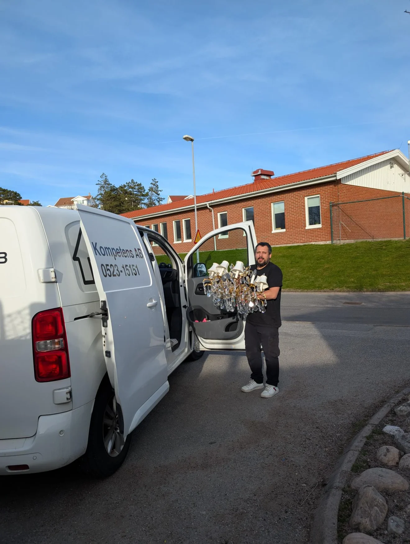 Flytthjälp i Lysekil: medarbetare bär en kristallkrona till JP Kompetens skåpbil