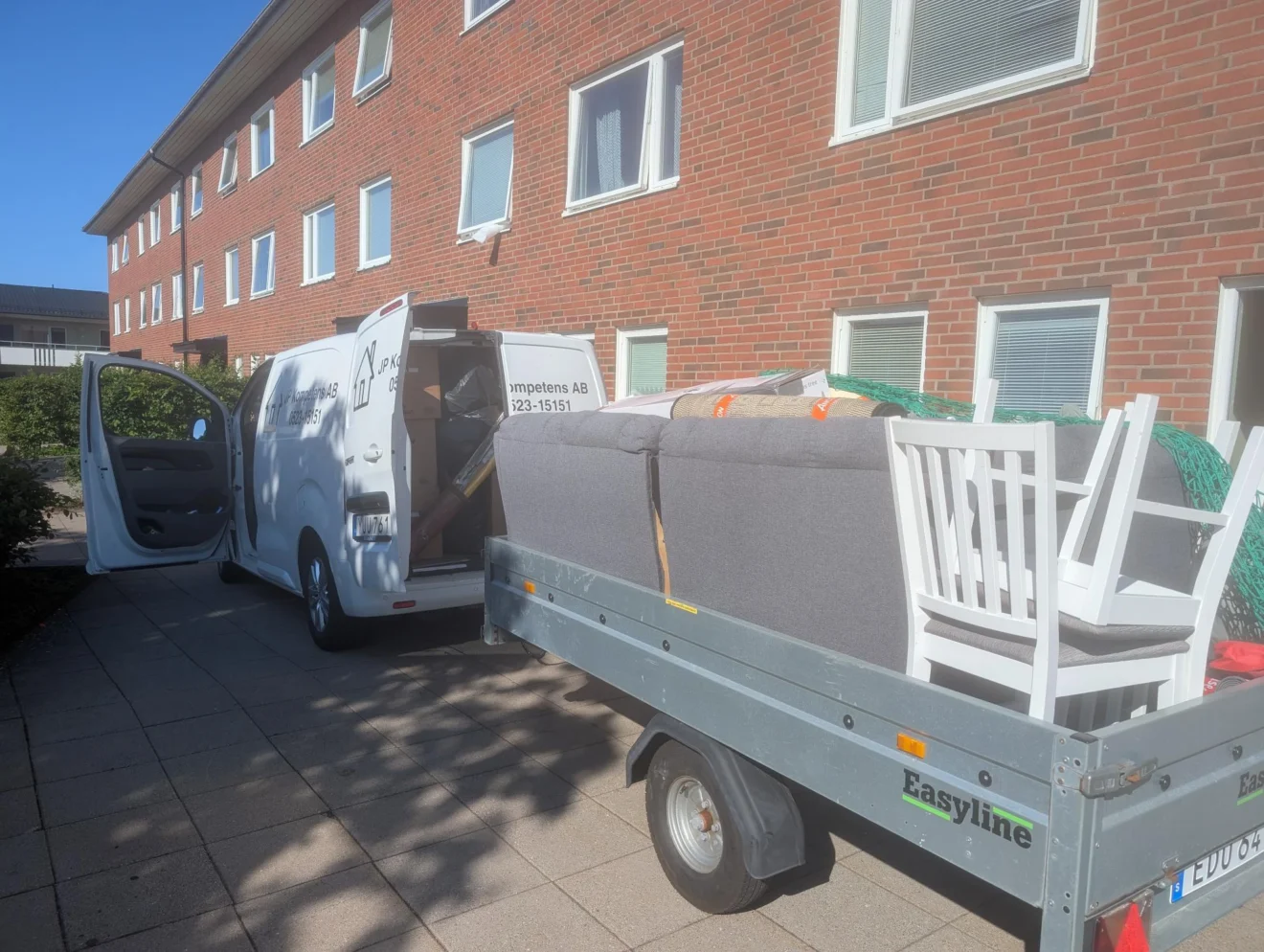 Flytthjälp i Lysekil: JP Kompetens skåpbil och släp lastade med soffa, stolar och flyttkartonger